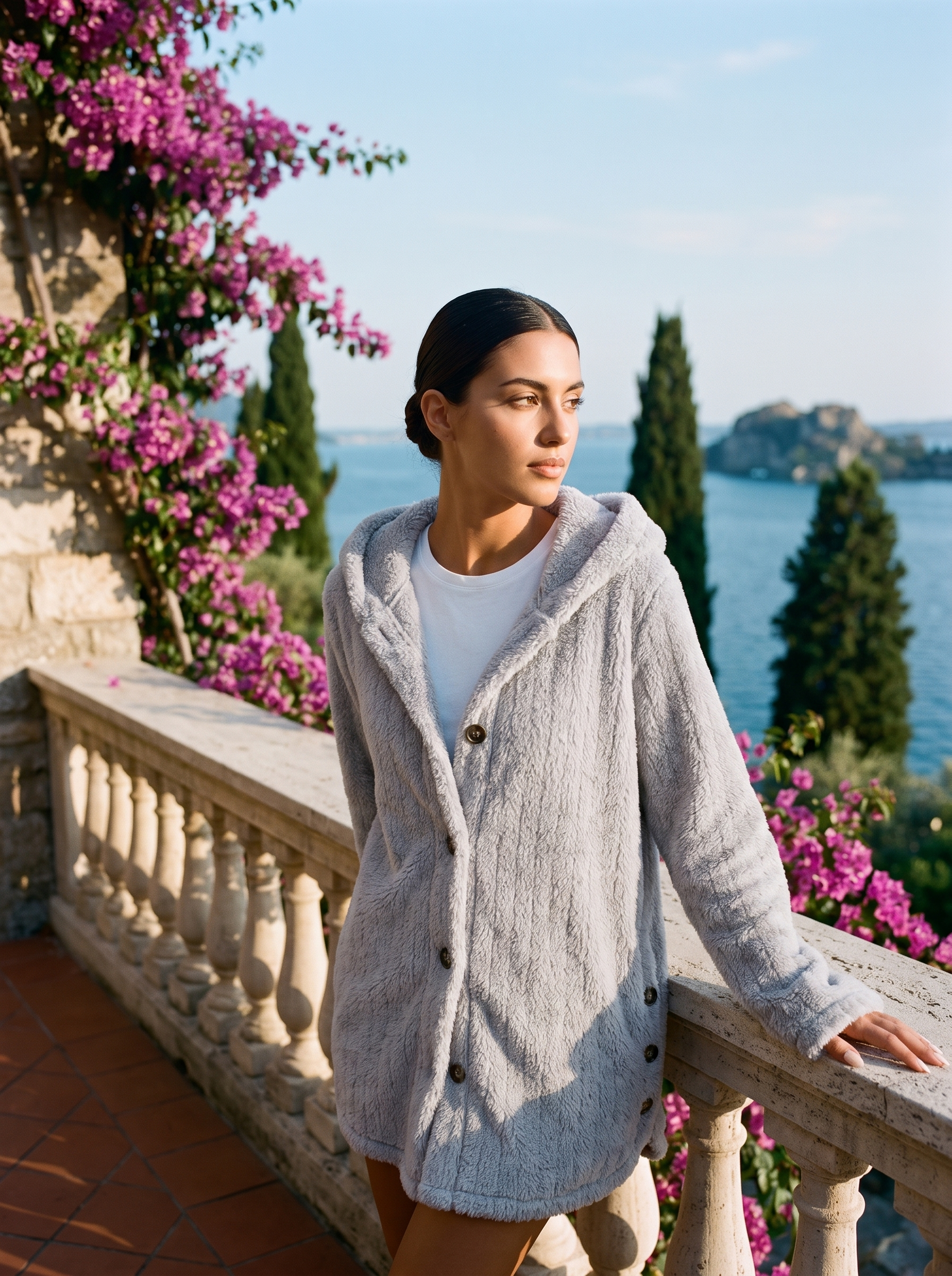 Woman wearing a gray hooded cardigan on a terrace overlooking Lake Como, old money style — Aveloire