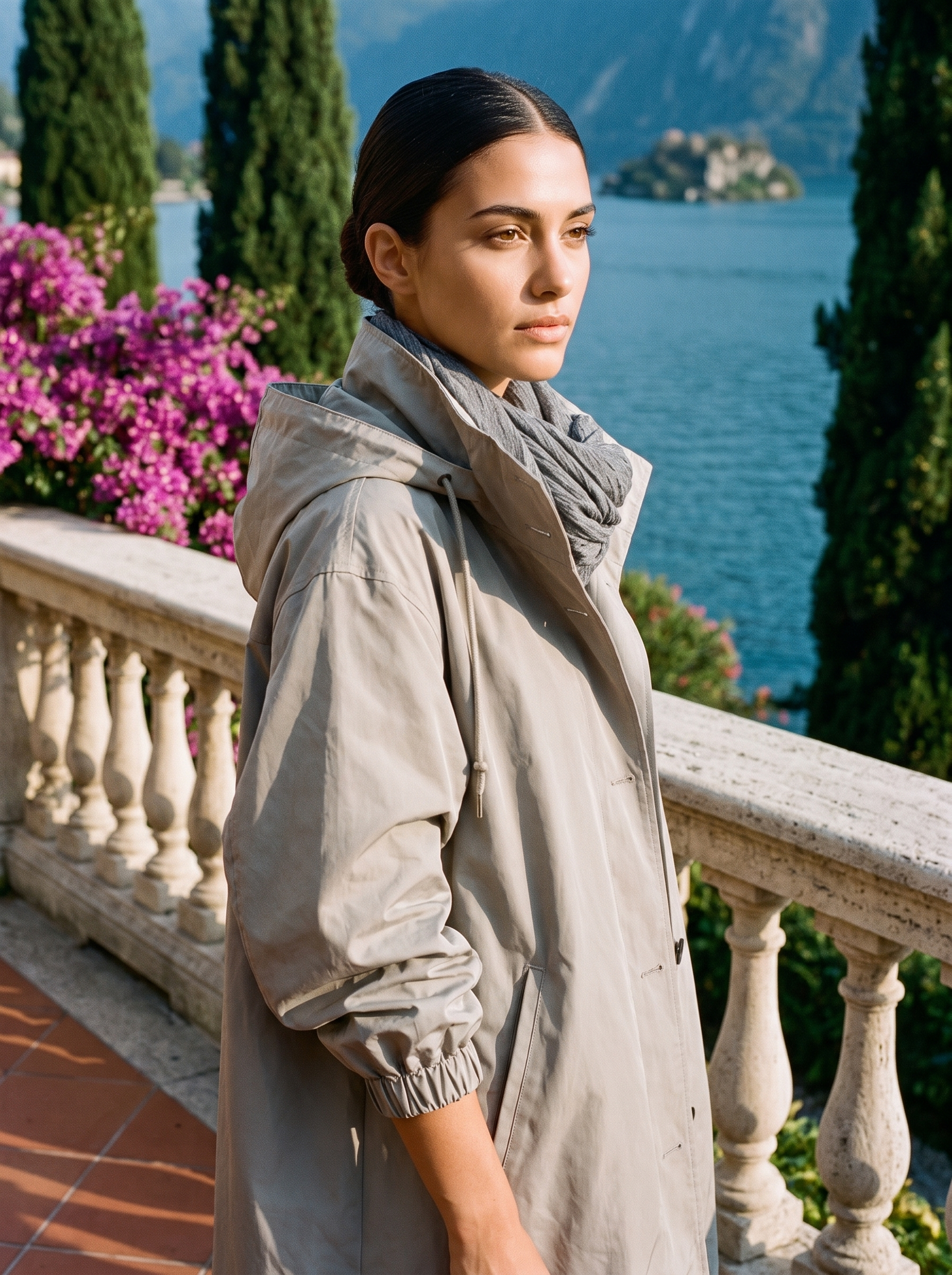 Woman wearing stone grey water-repellent hooded raincoat on a Lake Como terrace