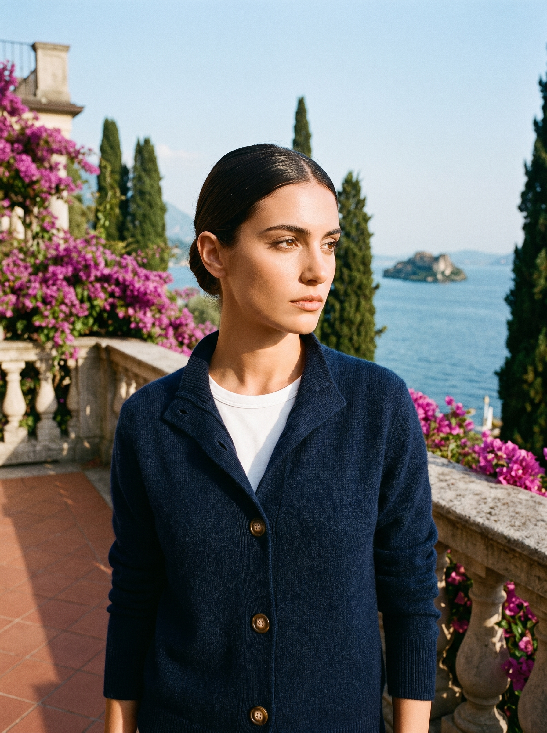 Woman wearing a navy blue stand-collar cardigan on a terrace overlooking Lake Como, old money style — Aveloire