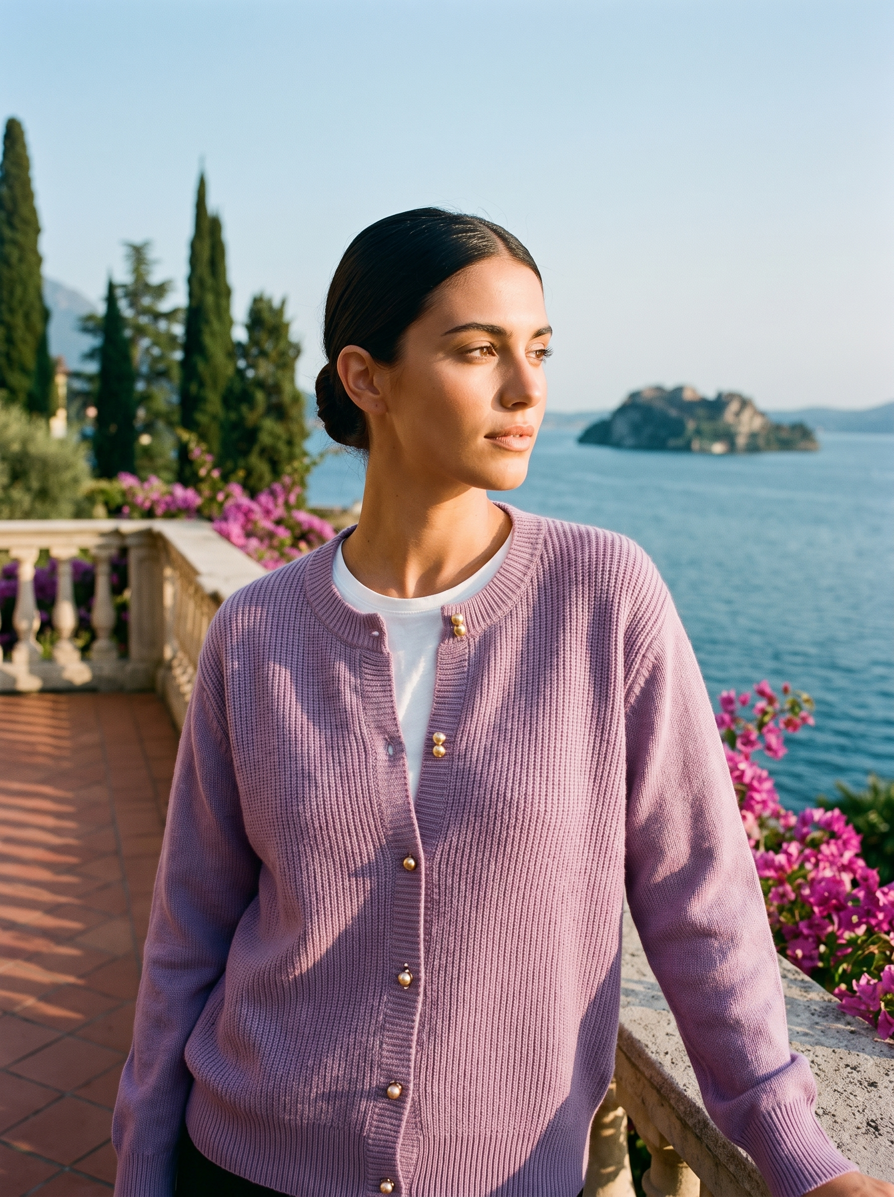 Woman wearing a purple round-neck cardigan on a terrace overlooking Lake Como, old money style — Aveloire