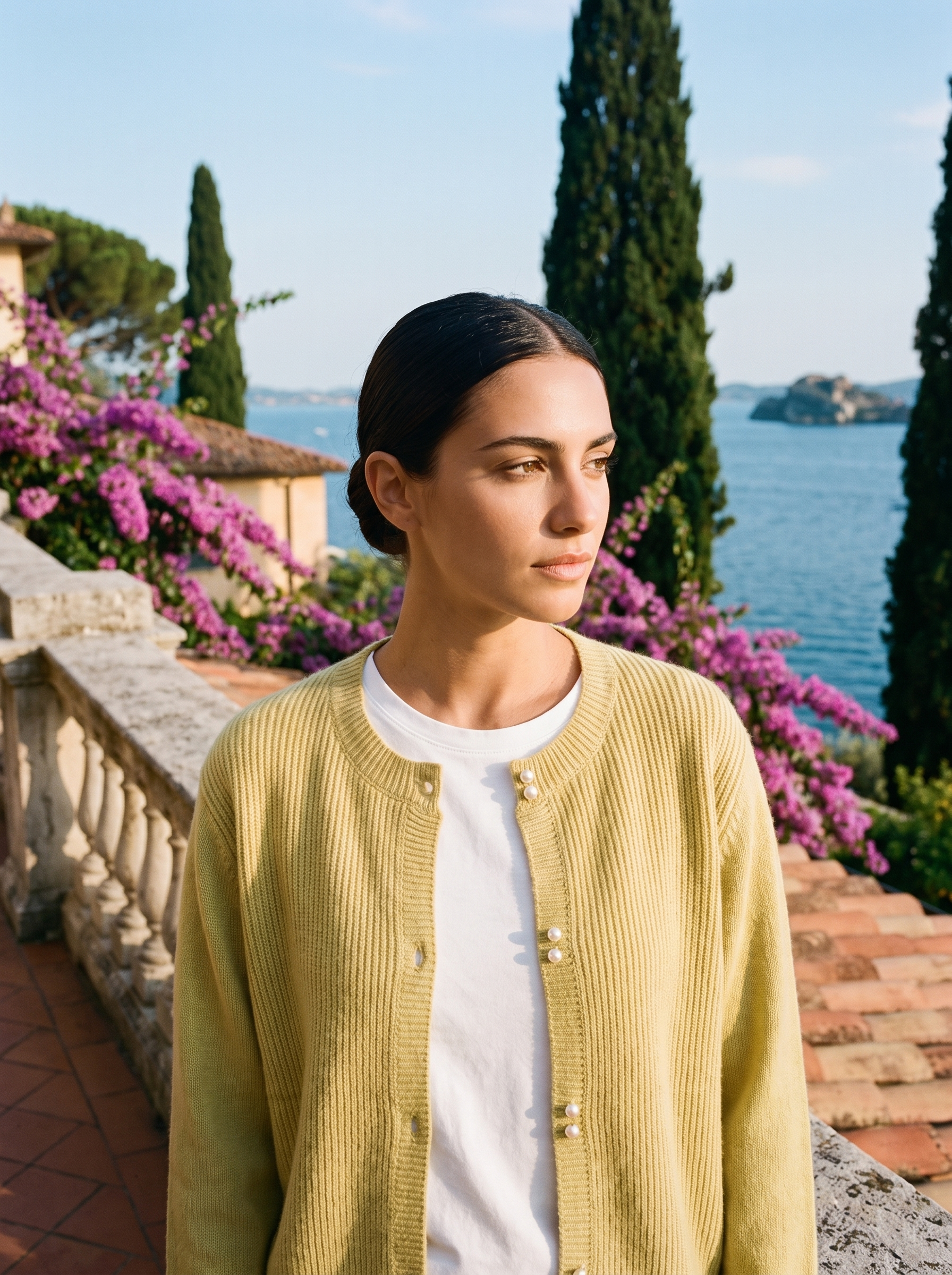 Woman wearing a yellow round-neck cardigan on a terrace overlooking Lake Como, old money style — Aveloire